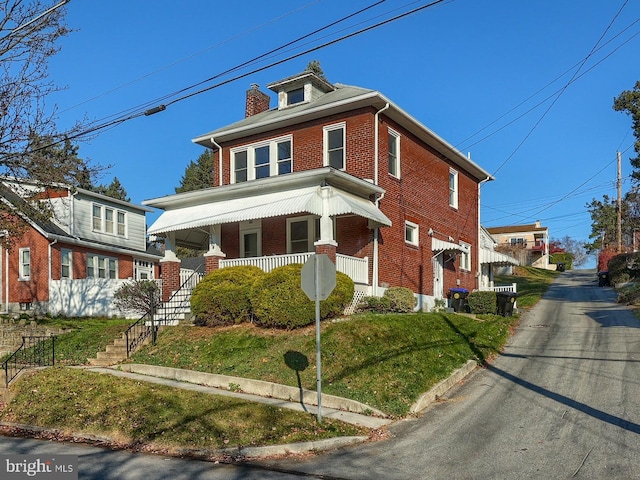 view of front facade with covered porch and a front lawn