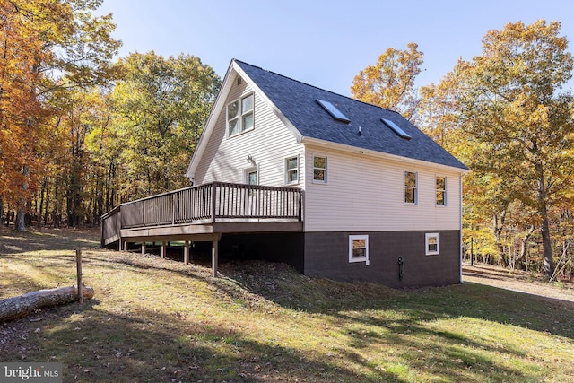 view of side of property featuring a lawn and a wooden deck