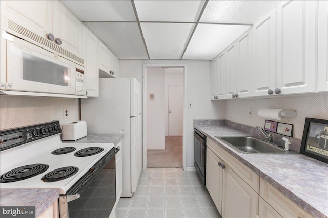 kitchen with white cabinetry, white appliances, and sink