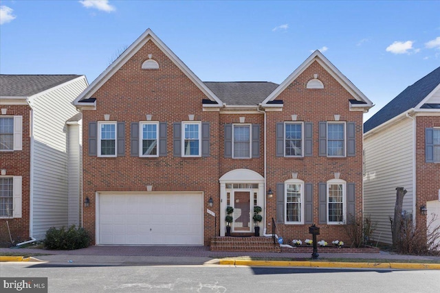 view of front of home featuring brick siding, an attached garage, and driveway