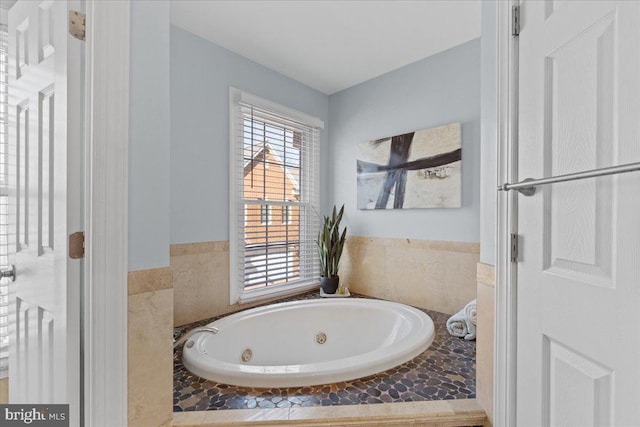 bathroom with a healthy amount of sunlight and a whirlpool tub