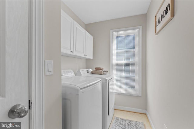 laundry area with cabinet space, washing machine and dryer, and baseboards