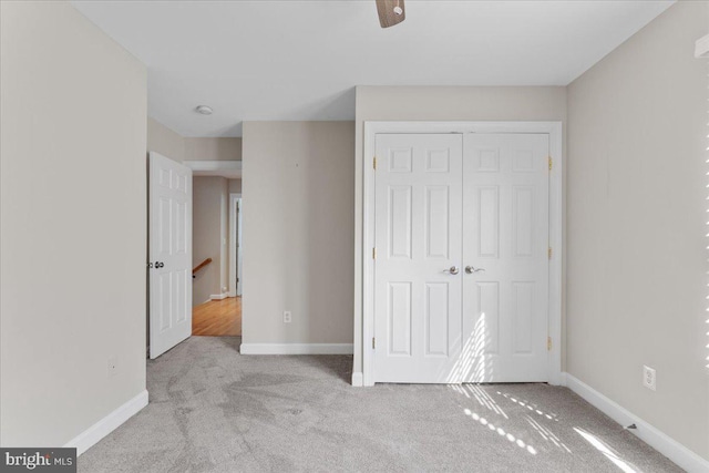 unfurnished bedroom featuring a closet, baseboards, and carpet floors