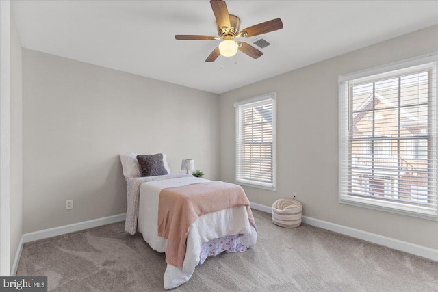 carpeted bedroom with visible vents, baseboards, and a ceiling fan