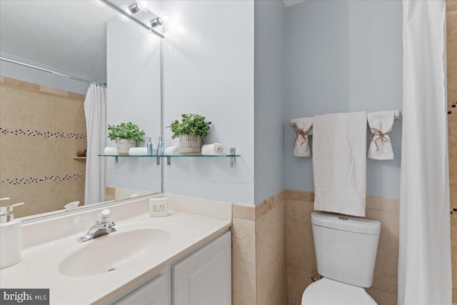 full bathroom featuring a wainscoted wall, toilet, curtained shower, tile walls, and vanity