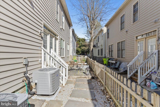 view of patio with central AC unit and fence