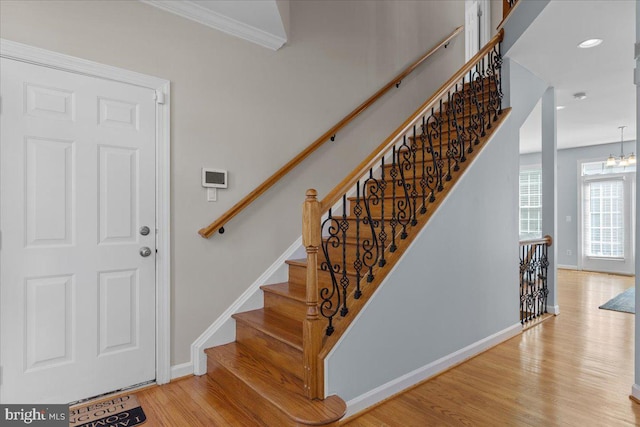 stairs featuring recessed lighting, wood finished floors, baseboards, and a chandelier