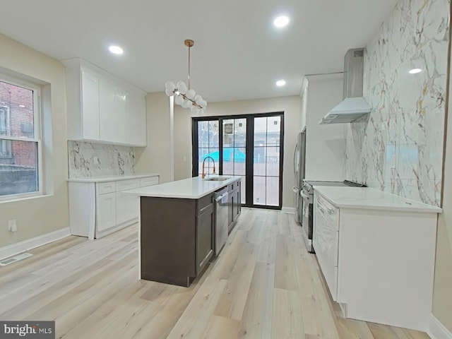 kitchen featuring backsplash, pendant lighting, stainless steel appliances, range hood, and white cabinets