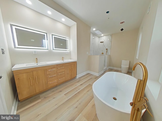 bathroom with wood-type flooring, independent shower and bath, and vanity