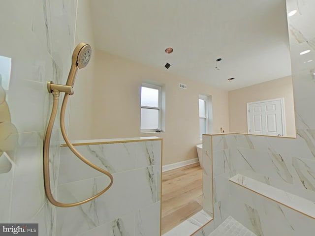 bathroom with hardwood / wood-style flooring and a shower