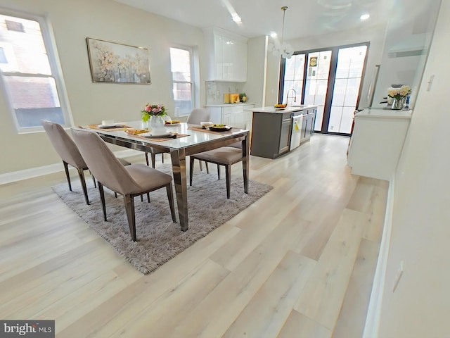 dining room featuring a chandelier, light hardwood / wood-style flooring, and a wealth of natural light