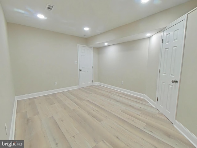 basement with light hardwood / wood-style flooring