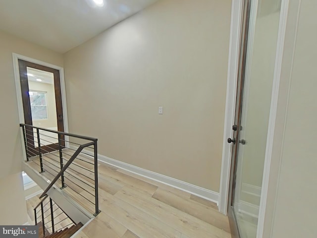 hallway with light hardwood / wood-style floors