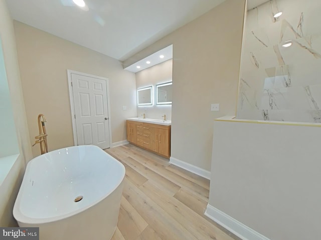 bathroom featuring vanity, hardwood / wood-style floors, and a washtub