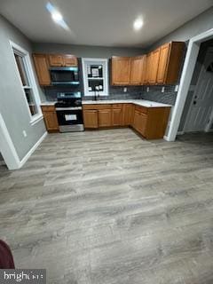 217 S 4th St, Vineland, NJ 08360 - kitchen featuring stainless steel gas range oven, brown cabinetry, light countertops, recessed lighting, and decorative backsplash