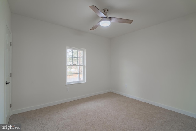 spare room with ceiling fan and light carpet