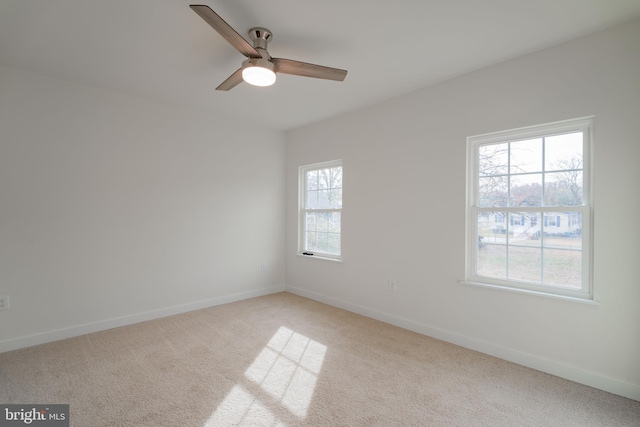 carpeted spare room featuring ceiling fan