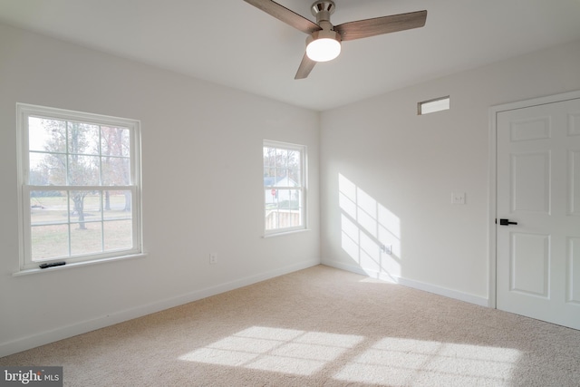 carpeted empty room with ceiling fan and a healthy amount of sunlight