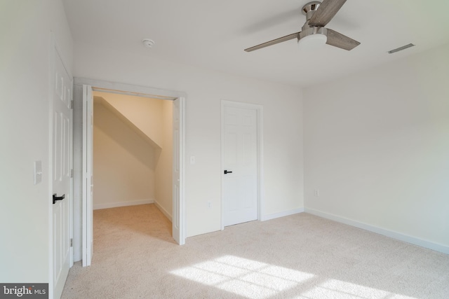 unfurnished bedroom featuring ceiling fan, light carpet, and a closet