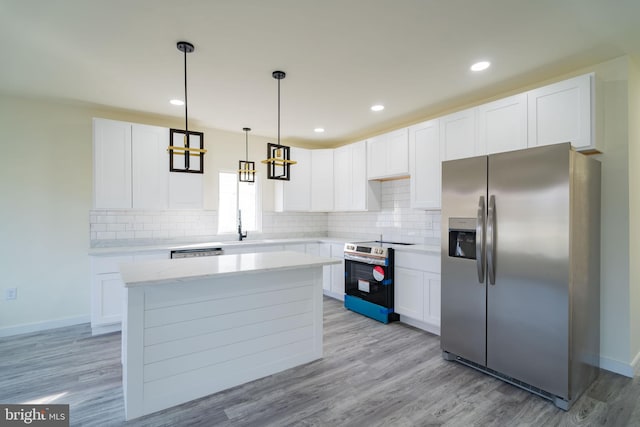 kitchen featuring pendant lighting, white cabinets, stainless steel appliances, and light hardwood / wood-style floors