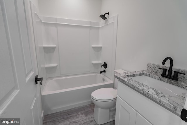 full bathroom featuring toilet, hardwood / wood-style floors, vanity, and washtub / shower combination