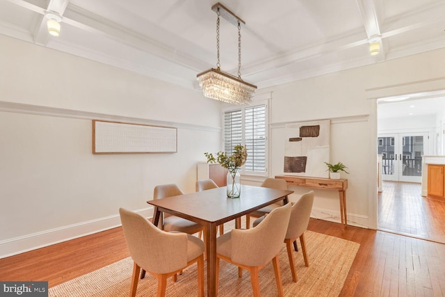 dining room featuring ornamental molding, beam ceiling, french doors, and light hardwood / wood-style flooring