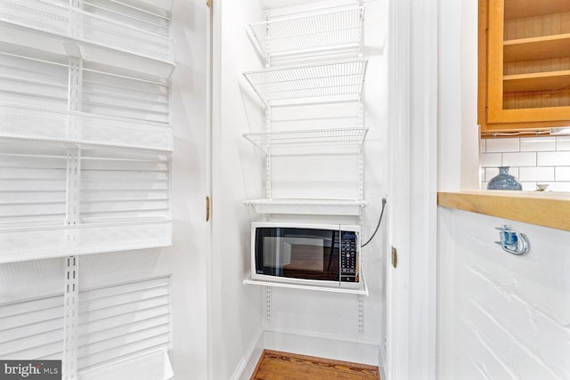 interior details featuring hardwood / wood-style flooring and tasteful backsplash