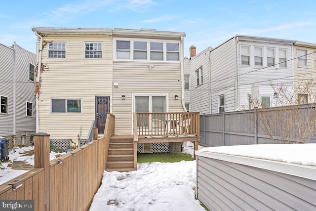 snow covered property with a deck