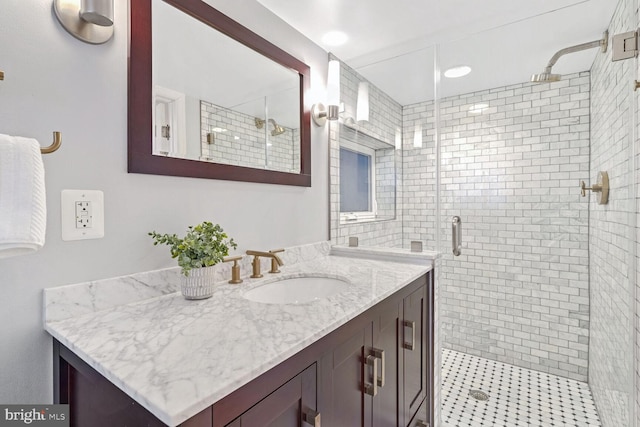 bathroom featuring vanity and a shower with door