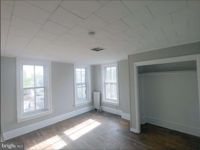 interior space with dark hardwood / wood-style floors and radiator