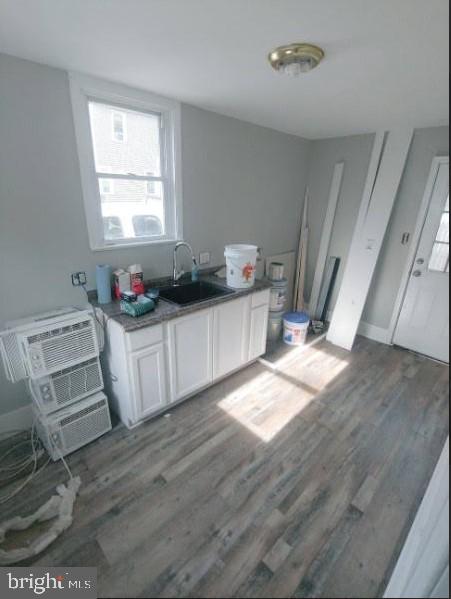 kitchen featuring white cabinets, dark hardwood / wood-style flooring, sink, and a wall mounted AC