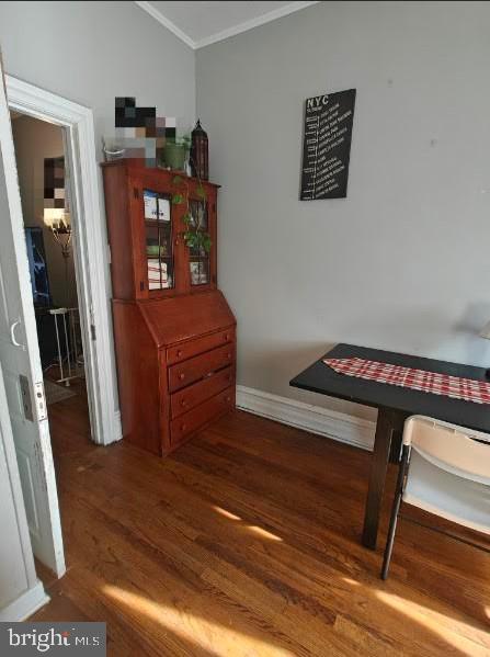 dining space featuring dark hardwood / wood-style floors and crown molding