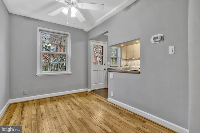 spare room featuring ceiling fan, sink, and light wood-type flooring