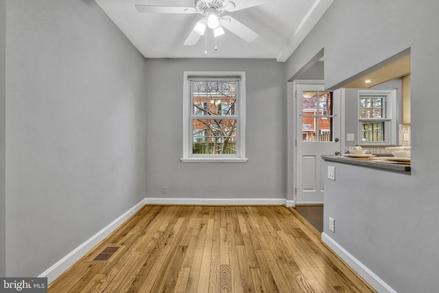 unfurnished dining area with ceiling fan and light hardwood / wood-style floors