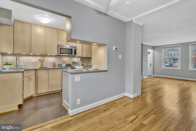 kitchen with sink, tasteful backsplash, light hardwood / wood-style floors, kitchen peninsula, and light brown cabinets