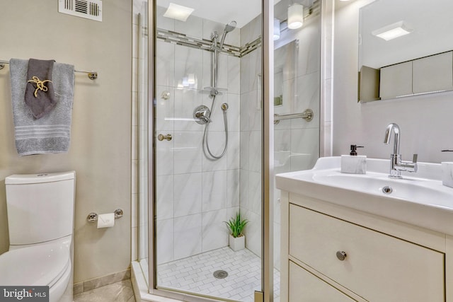 bathroom featuring vanity, an enclosed shower, and toilet