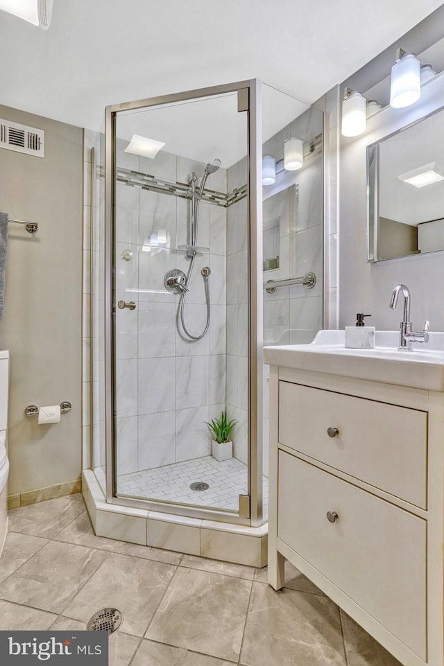 bathroom featuring vanity, toilet, and a shower with shower door