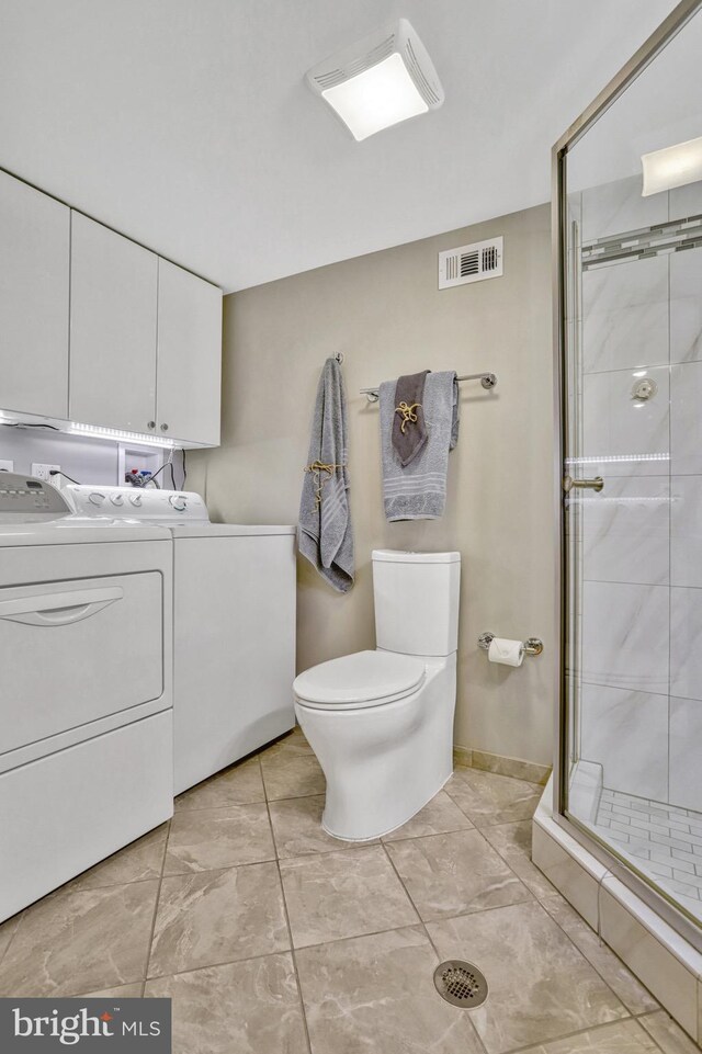 bathroom featuring vanity, a shower with door, toilet, and washing machine and clothes dryer