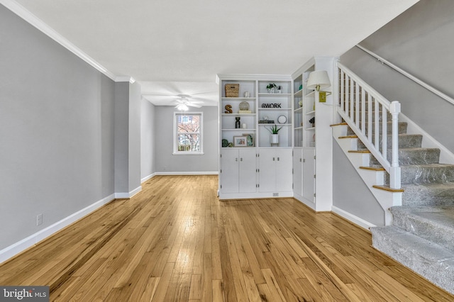 unfurnished living room featuring ornamental molding, ceiling fan, and light hardwood / wood-style flooring