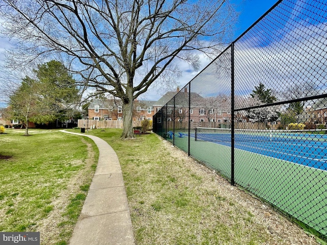 view of sport court featuring a lawn