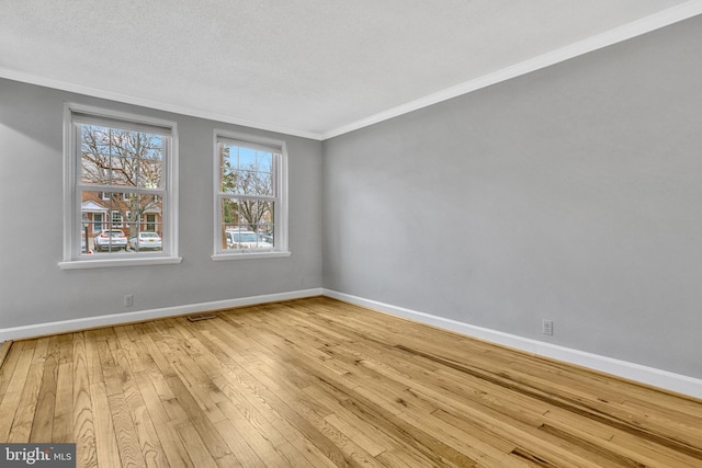 unfurnished room with hardwood / wood-style floors, crown molding, and a textured ceiling