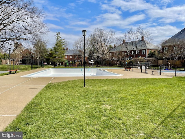 view of community featuring a yard and basketball hoop