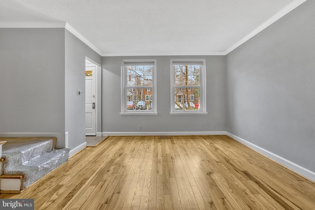 empty room featuring crown molding and light hardwood / wood-style floors