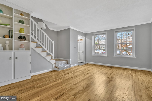 entryway featuring ornamental molding and light hardwood / wood-style flooring