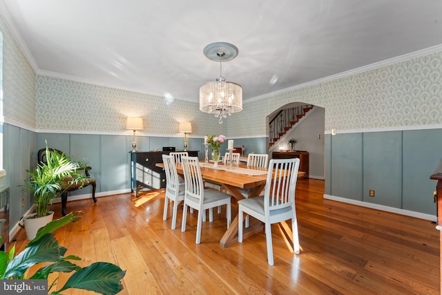 dining space featuring a chandelier, light hardwood / wood-style floors, and ornamental molding