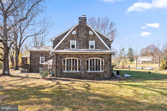 rear view of property with a lawn