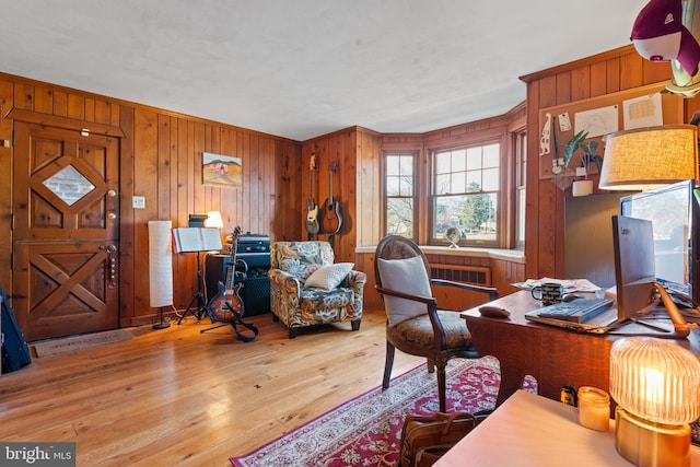 office space featuring light hardwood / wood-style floors and wood walls