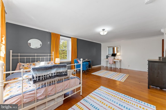 bedroom with hardwood / wood-style flooring and crown molding