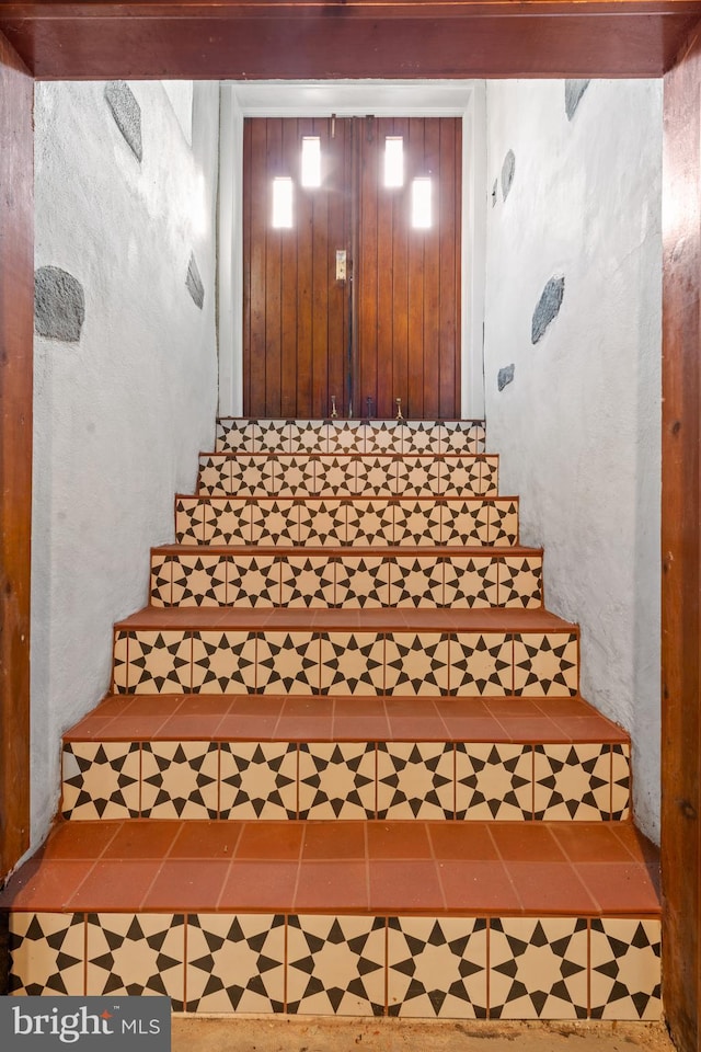 stairway with tile patterned floors