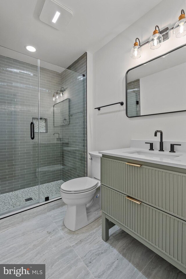 bathroom featuring vanity, toilet, and an enclosed shower